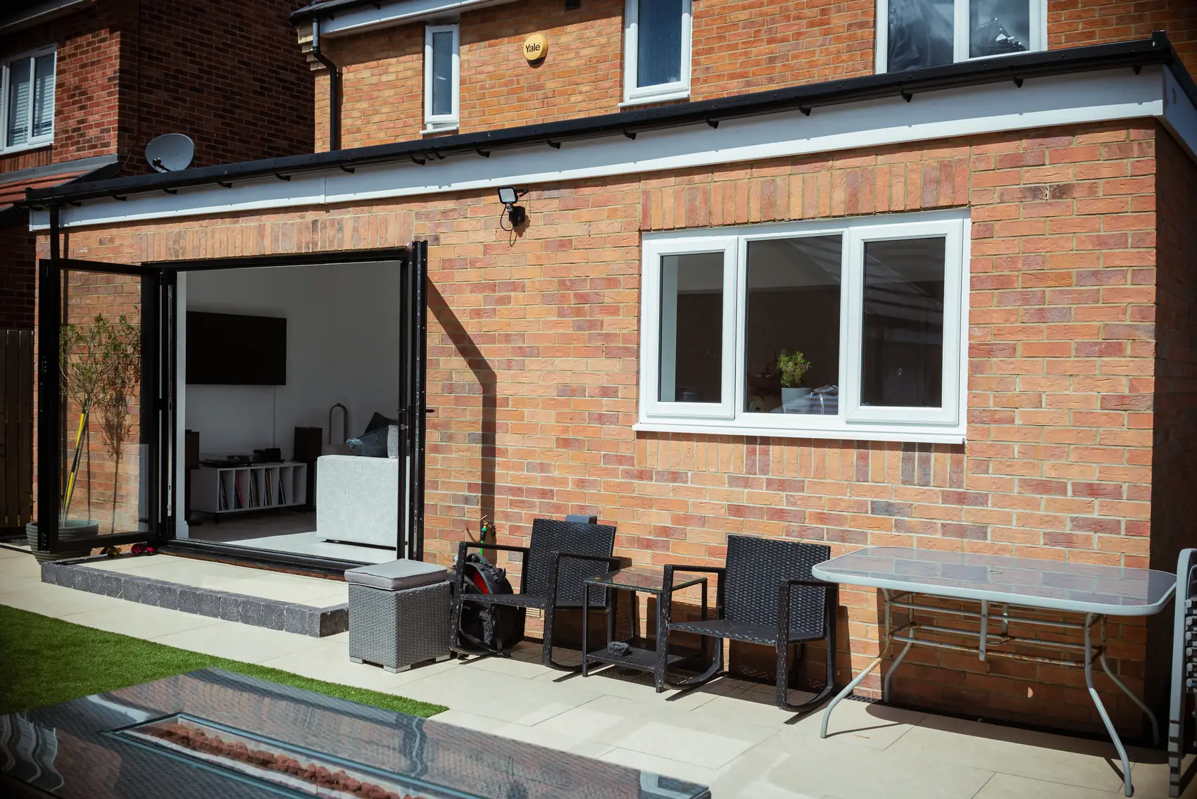 Brick rear extension with bi-fold doors and a raised patio seating area