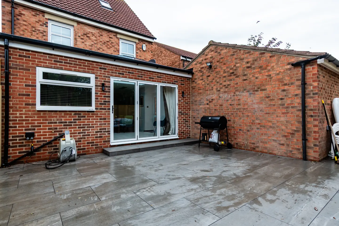 Brick-matched rear extension with sliding doors opening onto a new patio