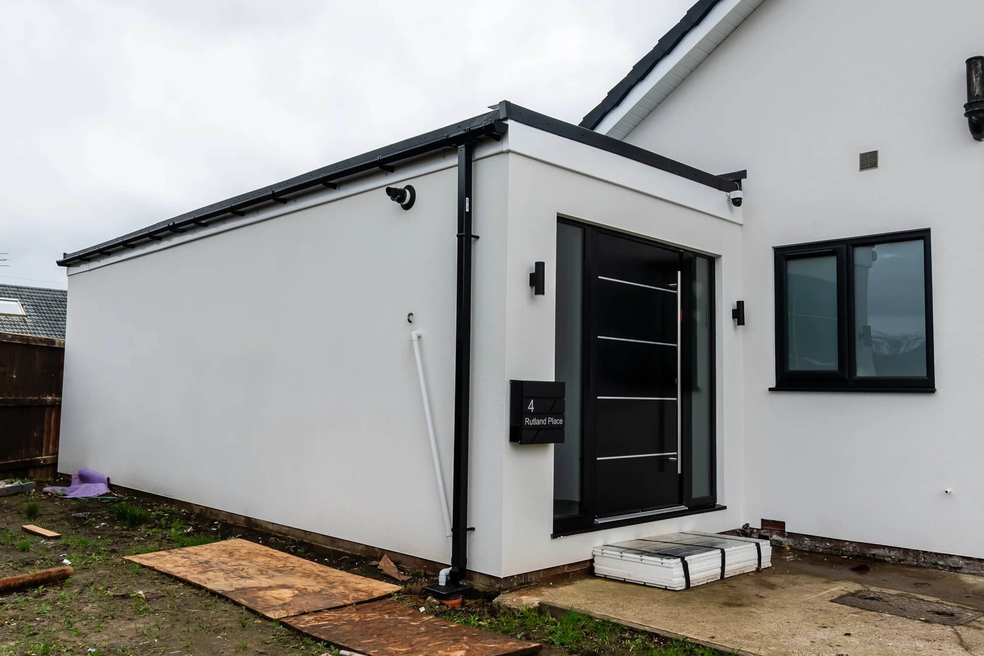 Detached garden room in white render with black composite door