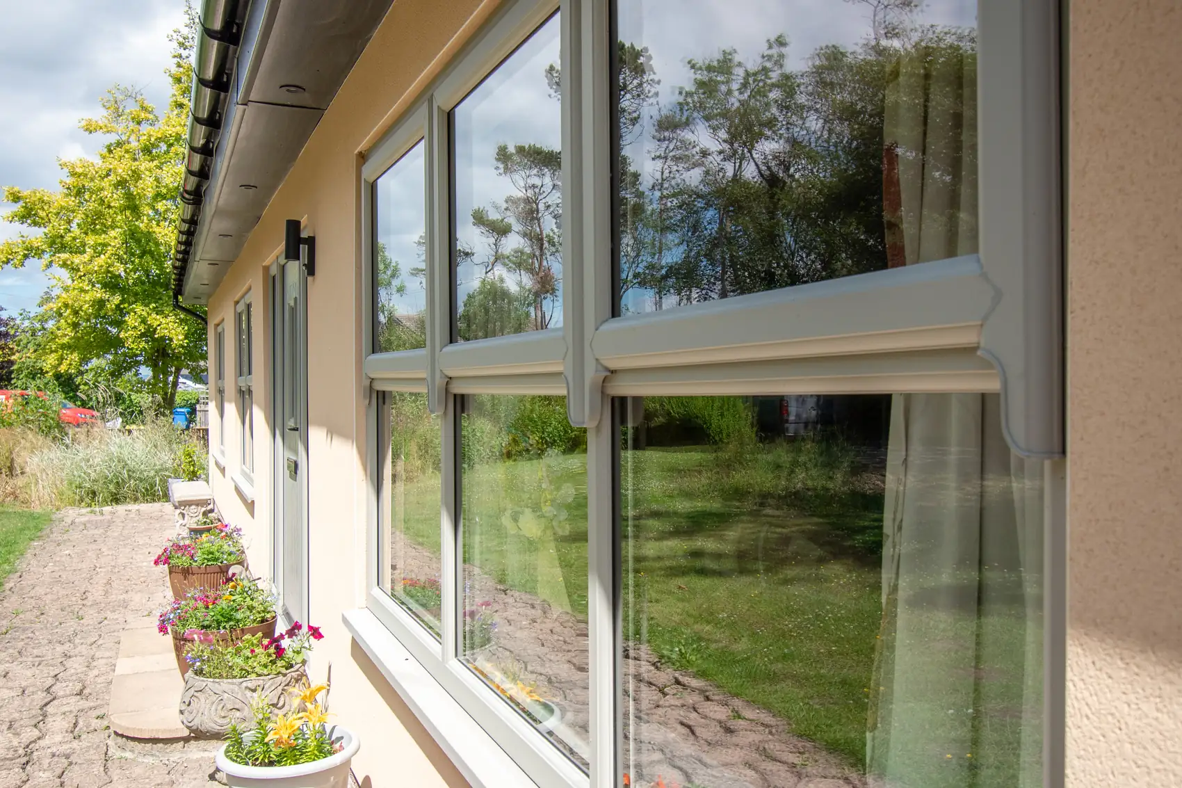 Full-height picture windows looking onto a mature garden